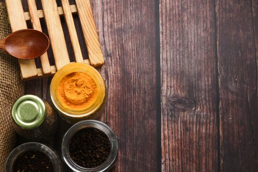 A top view of various seasonings and a wooden spoon on a table