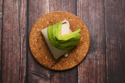 A top view of coconut flavored rice wrapped in banana leaves on a wooden table