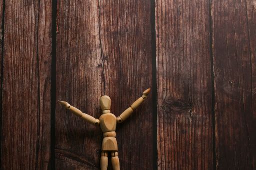 A top view of a small wooden figurine on a table background