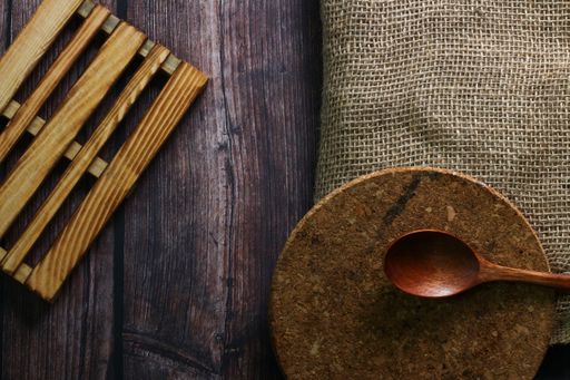 A top view of a spoon, board, and a piece of cloth on a wooden table