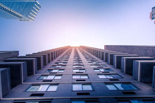 A low angle shot of a high rise tall building under blue sky