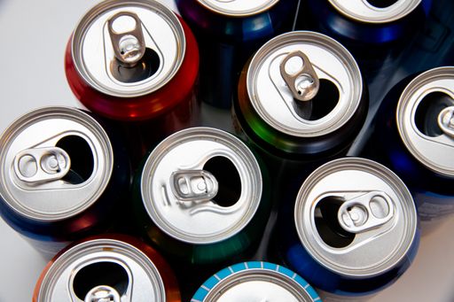 A top view of aluminum soda cans on a white surface