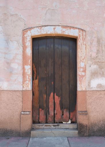 Antique wooden door facade with paint wear with copy space