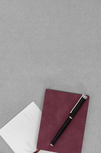 A vertical business style background with a notebook, pen, and envelope; a gray background with a copy space