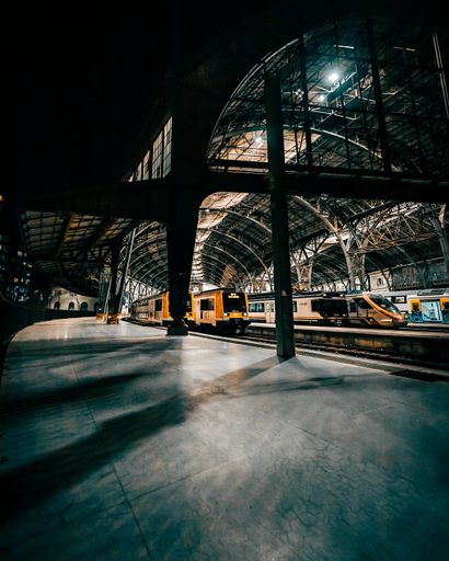 A dark wide-angle shot of the France railway Station in Barcelona showing some trains