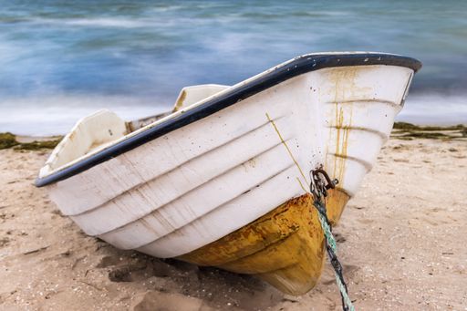 A closeup shot of an old metal boat on the seashore