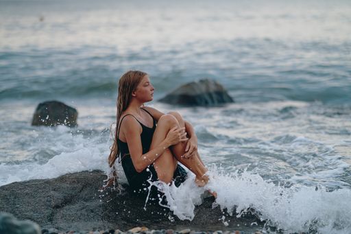 A scenic view of a model with a black dress posing for the picture on the beach
