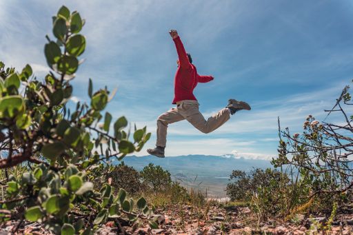 A man jumping and celebrating his achievements at the top of the mountain in Puebla, Mexico
