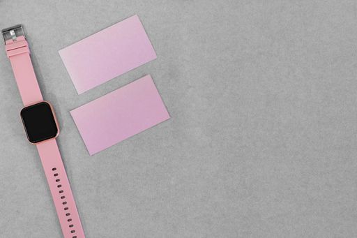 A top view shot of a grey surface with sticky notes with copy space and a watch
