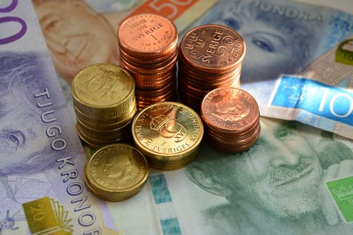 A close-up shot of Swedish krona bronze and golden coins on banknotes