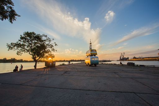 A wide shot of a bus, a van and a bicycle stacked on each other near the beach