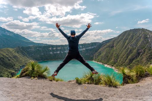 A Hispanic happy man celebrating his achievements nearby Laguna De San Luis Atexcac in Mexico