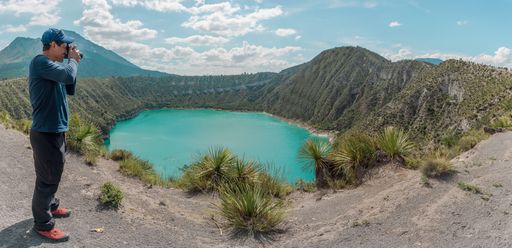 A panoramic shot of a Hispanic male person taking pictures of Laguna De San Luis Atexcac in Mexico