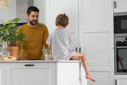 young man making homemade bread with his son in his home kitchen