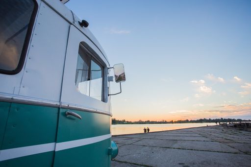 A side of a small Van parked near the beach