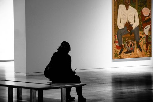 A person viewing a painting in an art gallery