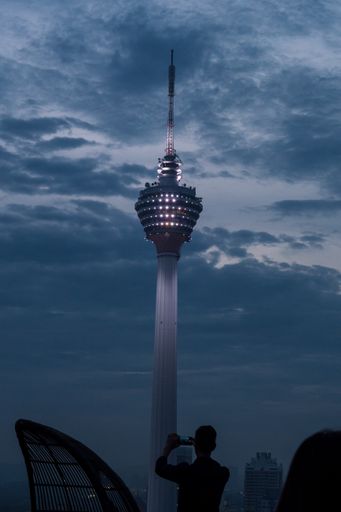 A vertical shot of a man taking a picture of Heli Lounge Bar in Kuala Lumpur, Malaysia
