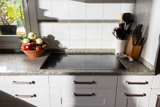 Bright empty kitchen with fresh vegetables ready to be cooked and cooking utensils, illuminated by sunlight