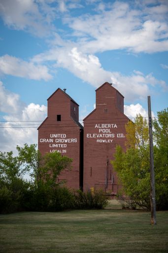 A vertical shot of the Historic wooden grain elevators in the ghost town of Rowley, Alberta with blue sky