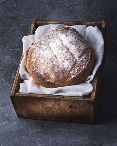 A closeup shot of a tasty fresh baked bread in the wooden box