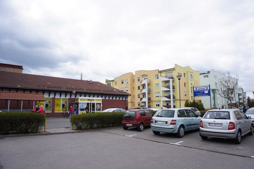 The parked cars on a parking lot near the supermarket and an apartment building in Poznan, Poland