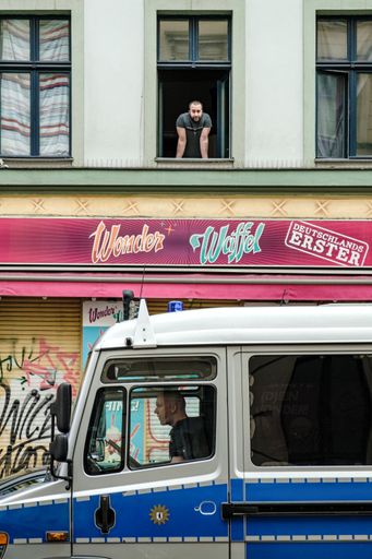 A young male looking out of the window in Berlin, Germany