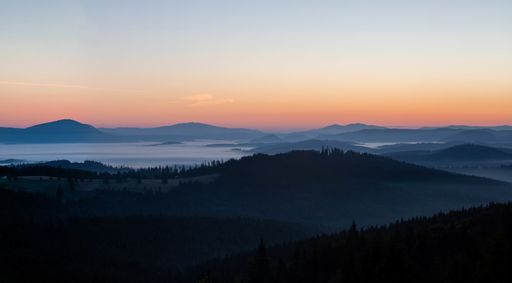 A view of landscape with sunrise over the mountains and fog in the valleys