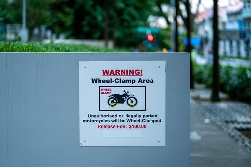 Warning sign , wheel-clamp area, Singapore . Horizontal shot