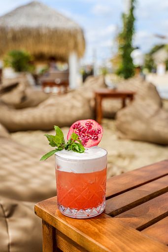 A vertical shot of a vibrant fruity cocktail at an outdoor resort