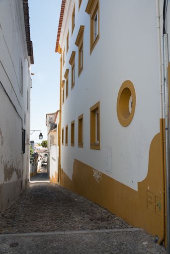 A beautiful shot of a thin path that goes through white buildings