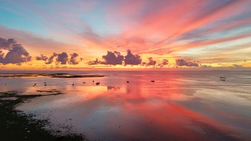 An aerial photograph of an extraordinary sunset over Nembrala beach with T-land reef visible in the distance- Rote, Indonesia