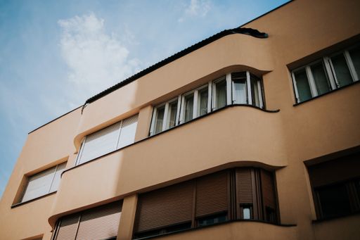 A low-angle shot of a beautiful residential house against the cloudy blue sky