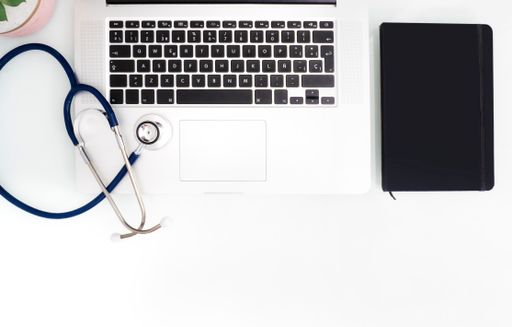 Stethoscope, laptop and notebook on white table with copy space. Medical concept.