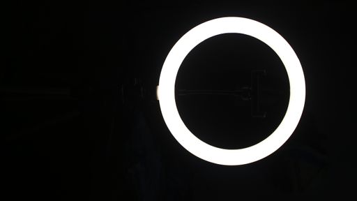 A vertical shot of a circle white led light lamp on a dark black background.