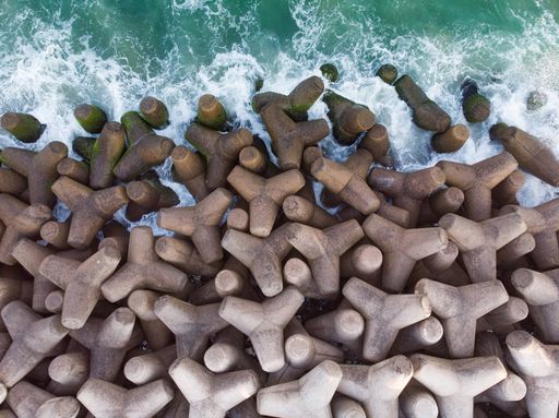 A top view shot of tetrapods at the edge of the sea