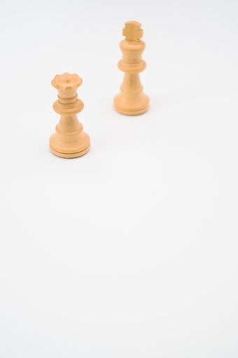 A vertical shot of white chess pieces isolated on a white background with copy space
