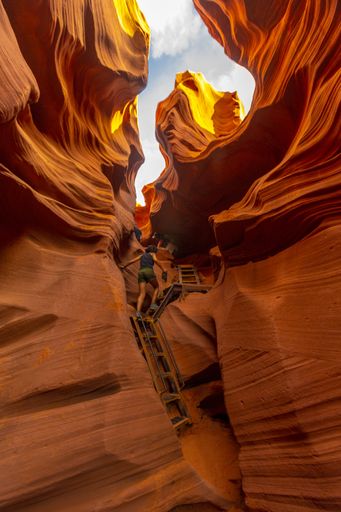 A vertical shot of a young tourist woman going upstairs to the Lower Antelope exit in Arizona, United States