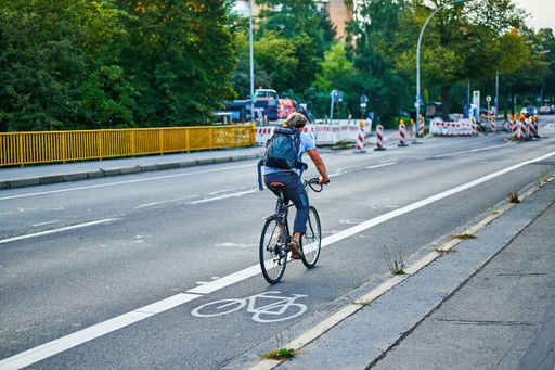 Berlin, Germany - September 10, 2021: Street scene with cyclist in Berlin. The cycle path was painted to give cyclists more space in traffic.