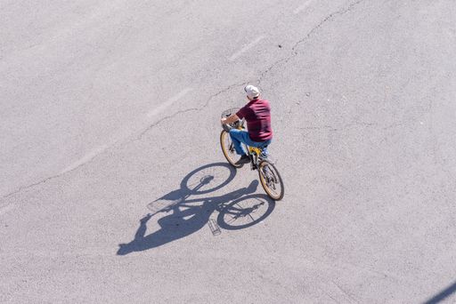 A young man bicycling on the street