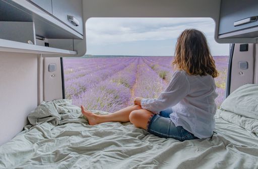 A woman looking at lavender fields from a camper