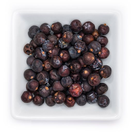 A top view of juniper berries in a white bowl