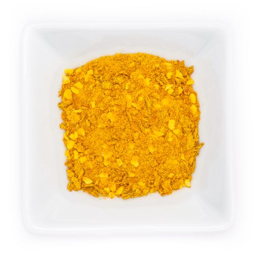 A top view of yellow spice mix for risotto in a white bowl
