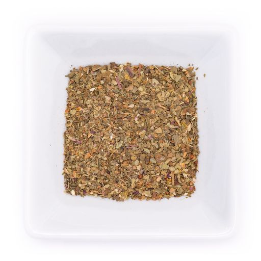 A top view of dried rubbed basil in a white bowl