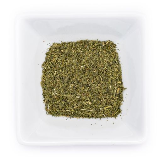 A top view of dried green dill tips in a white bowl