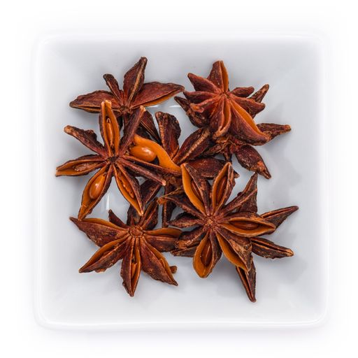 A top view of spice star anise in a white bowl