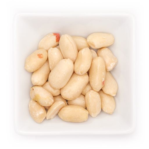 A top view of salted peanuts in a white bowl