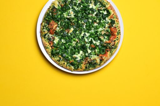 A top view shot of a pizza on a yellow background