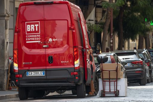 Delivery Man Uses Hand Truck Trolley Full of Cardboard Boxes and Packages, Loads Parcels into Truck Van. Caserta, Italy, Septrmber 13th 2021.