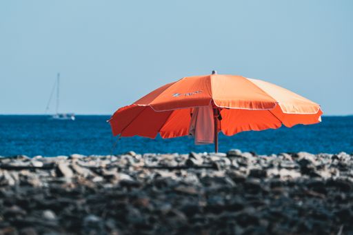 A selective focus shot of summer beach, parasol, blue sky and ships