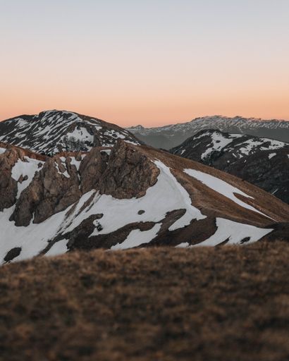 A vertical shot of a beautiful mountainous area covered with snow during the sunset